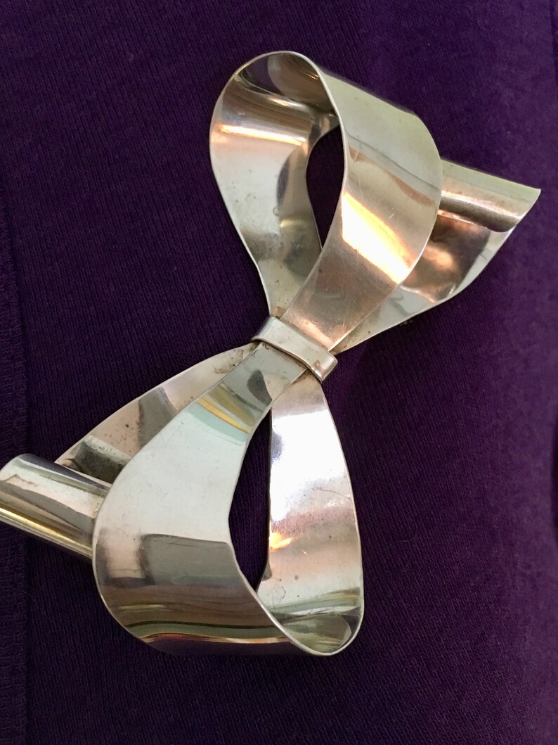 Large sterling silver bow brooch with curling ribbon ends