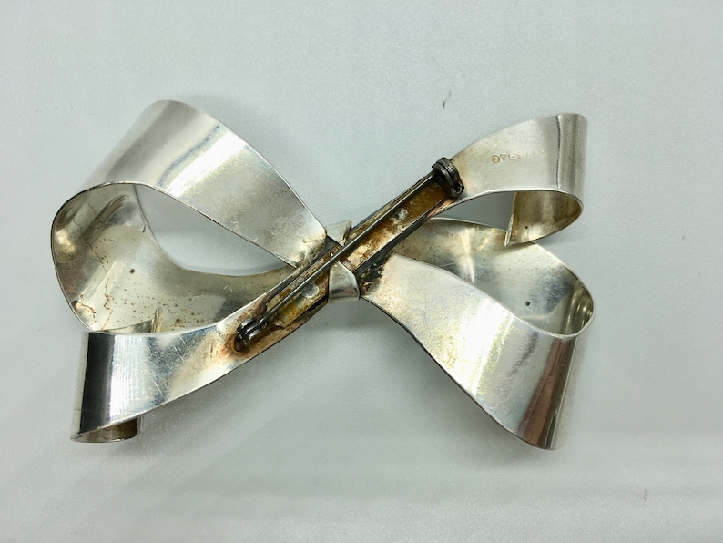 Large sterling silver bow brooch with curling ribbon ends