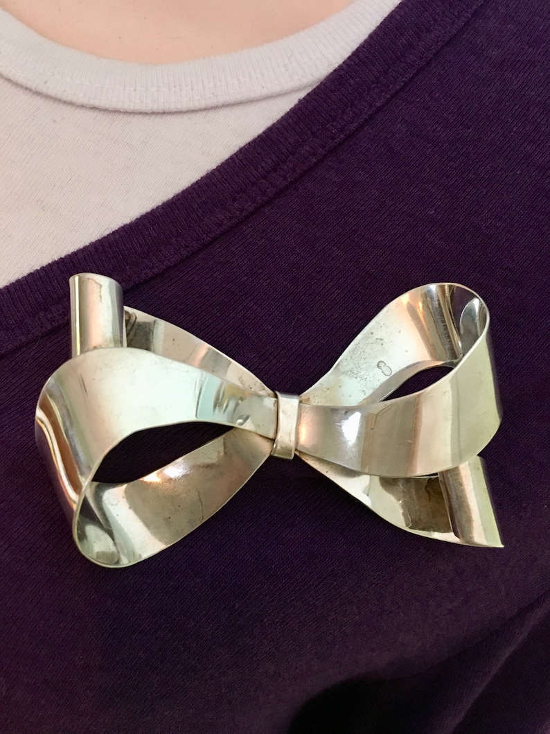 Large sterling silver bow brooch with curling ribbon ends