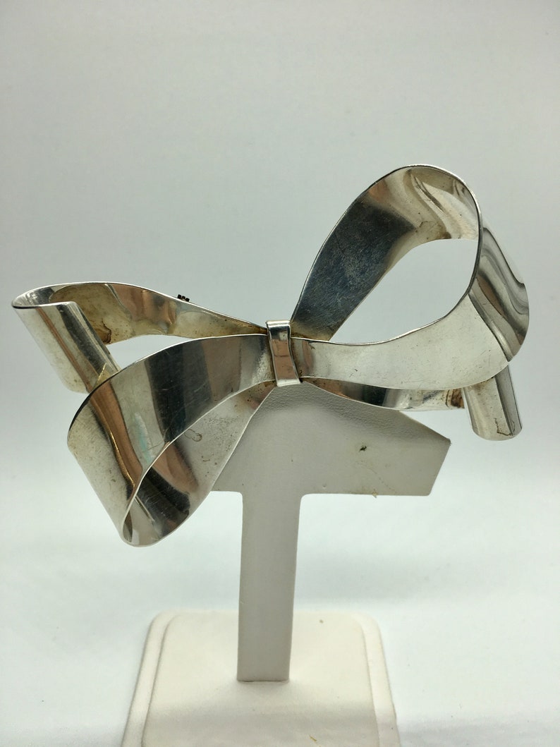 Large sterling silver bow brooch with curling ribbon ends