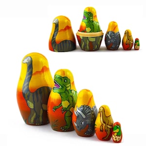 May include: A set of six nesting dolls, or matryoshka dolls, featuring different dinosaurs. The dolls are painted in bright colours with yellow, orange, and green hues. The largest doll depicts a long-necked dinosaur, followed by a Tyrannosaurus Rex, a Triceratops, a smaller dinosaur, and two smaller dinosaurs.