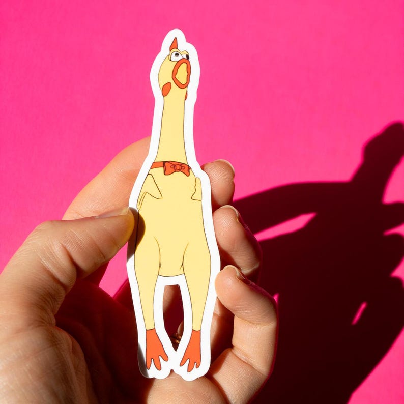 May include: A yellow rubber chicken sticker with a red bow tie and large eyes. The sticker is on a pink background.