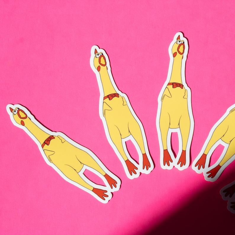 May include: Four yellow rubber chickens with red bow ties on a pink background. The chickens are all facing upwards with their beaks open.