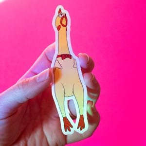 May include: A yellow rubber chicken sticker with a red bow tie and a surprised expression. The sticker is on a pink background.