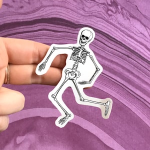 May include: A white skeleton sticker with a black outline, the skeleton is in a running pose with its arms outstretched.