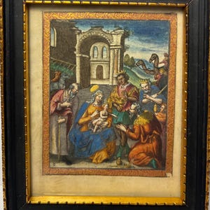 May include: Framed religious artwork depicting a biblical scene with figures in colorful robes. The artwork features a central figure holding a baby, surrounded by other figures. The frame is black with a gold inner border.