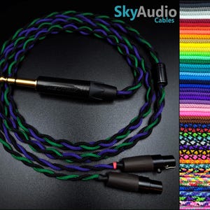 May include: A braided headphone cable with a black, green and purple colour scheme. The cable has a gold-plated 3.5mm jack on one end and two black 2.5mm jacks on the other end. SkyAudio Cables is printed on the image.