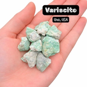 May include: A handful of variscite stones from Utah, USA. The stones are a mix of light green and gray, with a rough, natural texture. The text "Variscite" and "Utah, USA" are displayed in black boxes.