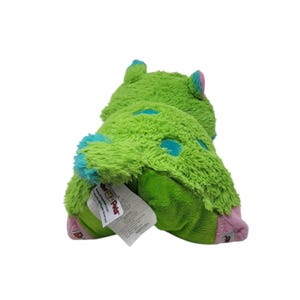 Puede incluir: Un peluche verde con lunares y detalles azules. El juguete tiene una textura peluda y una etiqueta adjunta. Las orejas y los pies son rosas. El juguete est&aacute; dise&ntilde;ado para parecerse a un monstruo.