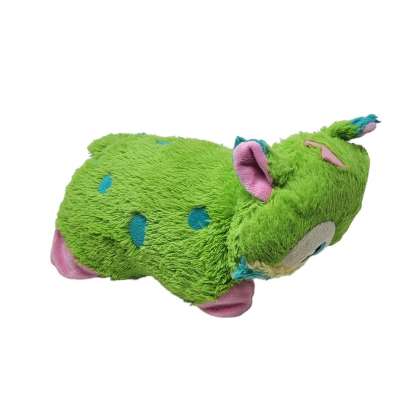 Puede incluir: Un peluche verde con forma de criatura con lunares azules, orejas rosas y detalles azules. El juguete tiene una textura suave y difusa y una expresi&oacute;n amigable. El juguete est&aacute; dise&ntilde;ado para ni&ntilde;os.