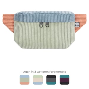 Peut inclure: Un sac banane en velours côtelé avec un compartiment principal vert clair, un panneau supérieur bleu clair et des ailes latérales corail. Le sac comporte deux tirettes de fermeture éclair noires et une étiquette de marque noire. Quatre échantillons.