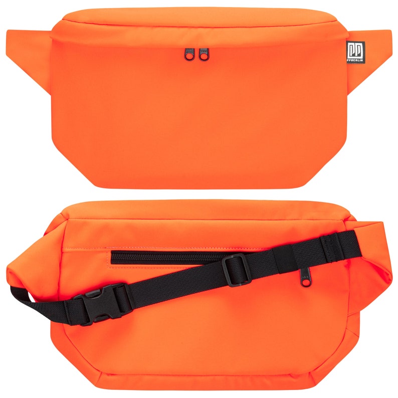 May include: A bright orange fanny pack with a black adjustable strap and a small black zippered pocket on the front. The pack has a black logo that says "PD FREELIK" on the right side.