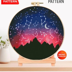 May include: A cross-stitch pattern displayed in a wooden hoop, featuring a night sky design with constellations, a crescent moon, and a mountain silhouette. The text "CROSS STITCH PATTERN" and "PDF PATTERN" are visible.