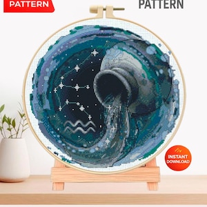 Op de afbeelding: Een kruissteekpatroon met het sterrenbeeld Waterman, in blauwe en blauwgroene tinten. Het ontwerp toont een waterkan die water giet, sterren en de tekst "CROSS STITCH PATTERN". Het PDF-patroon is direct te downloaden.