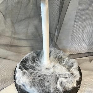 May include: A black and white Halloween tree with a black tulle skirt and white spider web base.