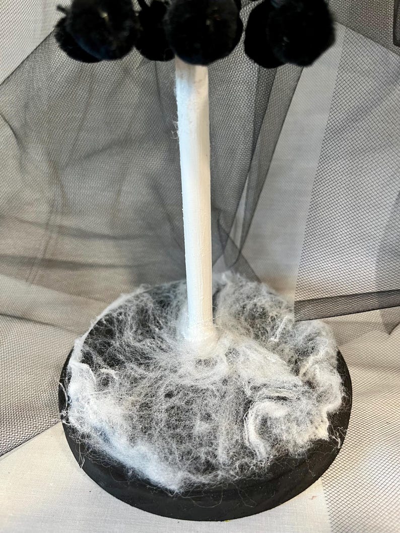 May include: A black and white Halloween tree with a black tulle skirt and white spider web base.