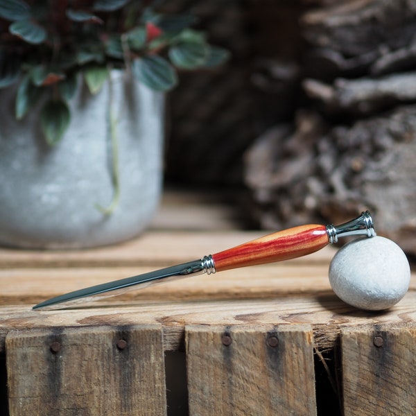 Letter opener with a wooden handle made from Brazilian tulip wood in either gold or chrome fittings . Retirement. Housewarming.