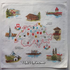 Könnte beinhalten: Weißes Baumwolltaschentuch mit einer Karte der Schweiz, illustriert mit Sehenswürdigkeiten und Städten. Das Taschentuch misst 30 x 30 cm und enthält Text in mehreren Sprachen.