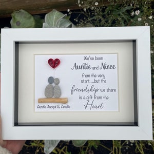 May include: A white framed picture with a white background and a gray and red paper heart. The picture says "We've been Auntie and Niece from the very start...but the friendship we share is a gift from the Heart".