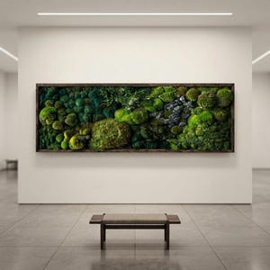 May include: A rectangular wall art piece featuring a dense arrangement of preserved green moss in various shades, textures, and shapes, encased in a dark brown wooden frame. The composition includes clusters of rounded and fern-like foliage.