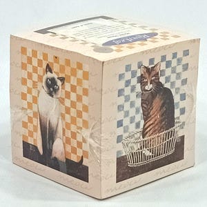 May include: A wooden box with a checkered pattern and two cats. One cat is a Siamese with blue eyes and the other is a tabby cat. The box has the text "Perfect Cat" on the top.