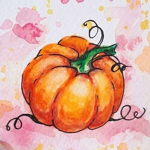 May include: A rectangular watercolor painting on textured paper featuring a vibrant orange pumpkin with a green stem and black ink outlines. The background consists of abstract pink and yellow paint splatters. A small artist signature is in the corner.