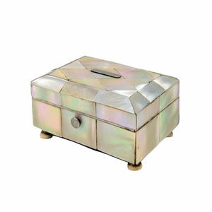 May include: A rectangular jewelry box with a mother-of-pearl mosaic design. The box has a small drawer with a round silver knob and rests on four small, rounded feet. A silver-colored metal accent is on the lid.