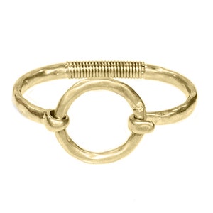 Pode incluir: Um bracelete dourado com um design de círculo aberto grande. O bracelete é feito de metal e tem um fecho de mola.