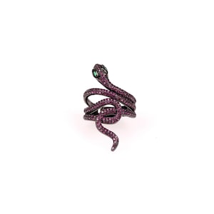 May include: A black snake ring with pink and green stones. The snake is coiled around a band and has a raised head.