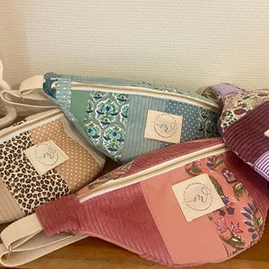 Peut inclure: Collection de cinq sacs banane faits à la main, aux couleurs et motifs variés. Les motifs comprennent des imprimés léopard, floraux, du velours côtelé et des rayures. Chaque sac est doté d'une fermeture éclair et d'une petite étiquette.