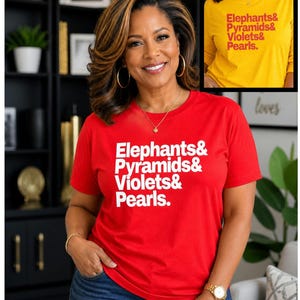 May include: A red t-shirt with the text "Elephants & Pyramids & Violets & Pearls" in white. The image also shows a yellow long-sleeved shirt with the same text. The shirts are worn by a person.