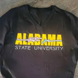 May include: Black v-neck t-shirt with a yellow graphic that says "ALABAMA beta pi STATE UNIVERSITY".