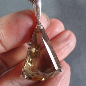 Peut inclure: Un collier en argent avec un pendentif en forme de larme orn&eacute; d'une grande pierre pr&eacute;cieuse brune facet&eacute;e.