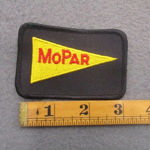May include: Black rectangular patch featuring a yellow pennant with red "MoPAR" text. The patch is approximately 10 cm long. The patch has a black border and is likely an embroidered emblem.