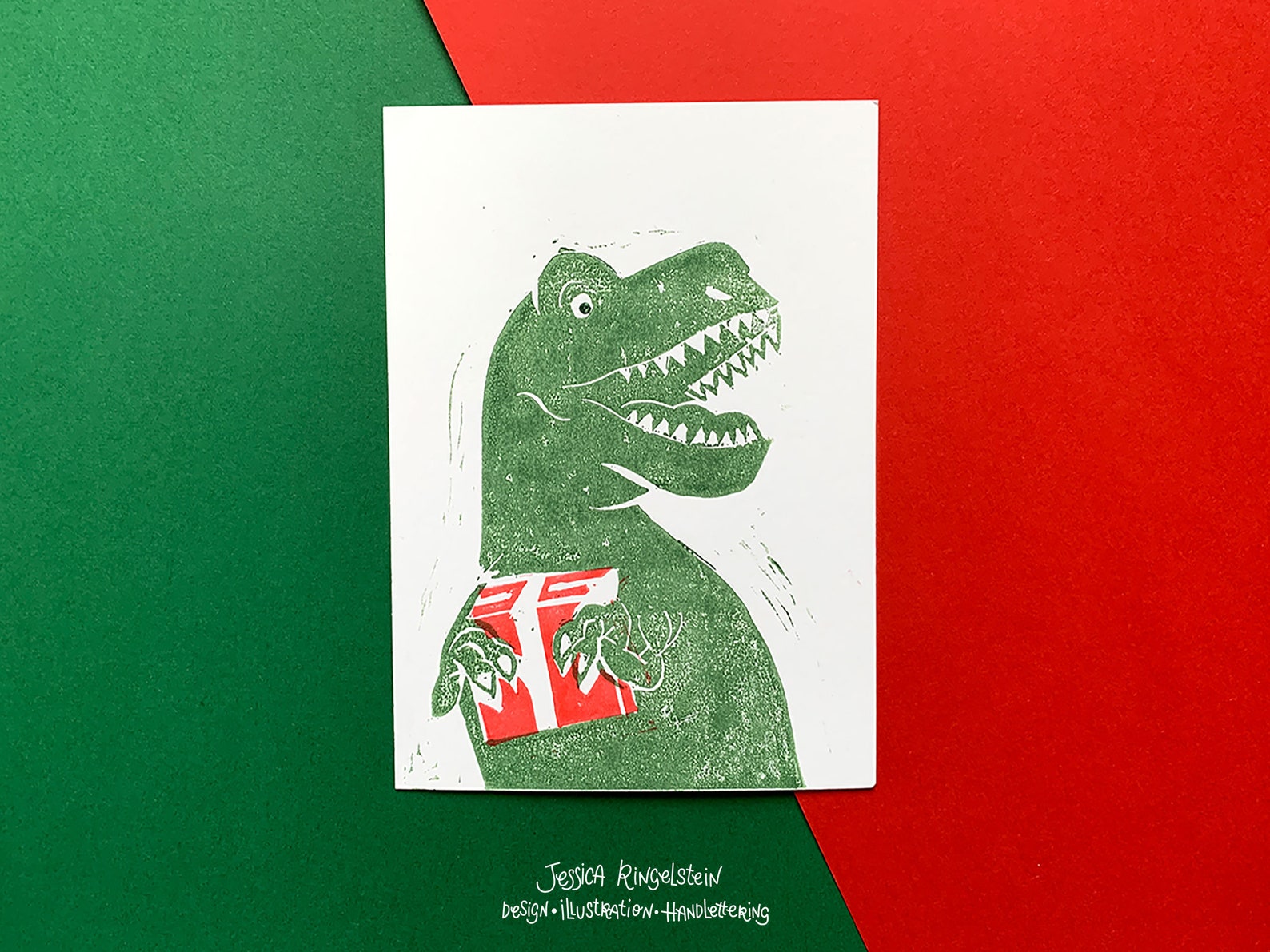 Photograph of linocut card showing a t-rex with a wrapped gift