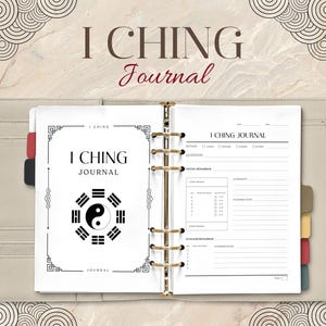 May include: An open I Ching journal with a cream-colored cover and gold-colored rings. The journal's cover features the text "I Ching Journal" in a decorative font. The journal pages have a yin-yang symbol and space for notes.