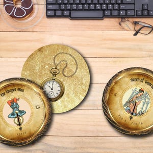 May include: Three decorative coasters with tarot card designs. One coaster features a pocket watch on a gold background. The other two coasters have gold rims and display tarot card illustrations, including "The Hanged Man" and "Seven of Swords."