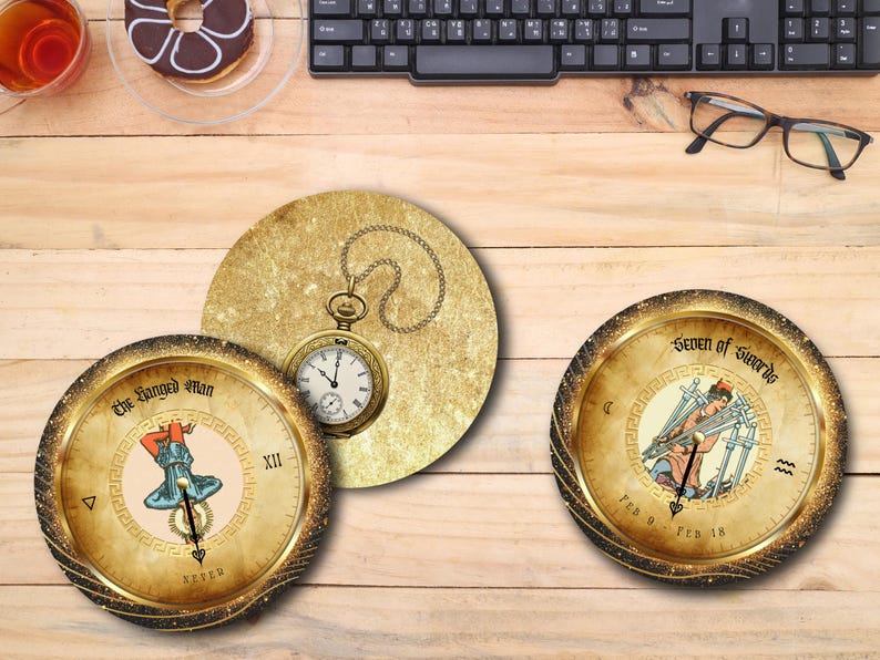May include: Three decorative coasters with tarot card designs. One coaster features a pocket watch on a gold background. The other two coasters have gold rims and display tarot card illustrations, including "The Hanged Man" and "Seven of Swords."