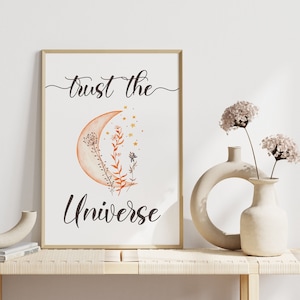 May include: A printable wall art design featuring a crescent moon with a watercolor effect, surrounded by small stars and stylized floral elements. The text "Trust the Universe" is written in a cursive font below the moon.