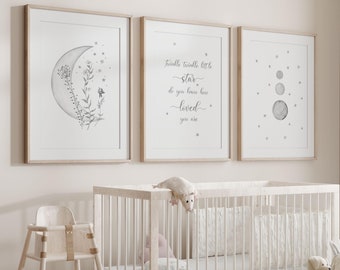Puede incluir: Una cuna blanca con un colchón blanco y una silla alta de madera blanca. Hay tres impresiones enmarcadas en la pared sobre la cuna. Las impresiones muestran una luna creciente con estrellas, una cita sobre una estrella y una luna creciente con estrellas. Hay animales de peluche en una cesta en el suelo.