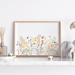 May include: A framed watercolor painting of a field of wildflowers in shades of pink, yellow, and purple. The flowers are arranged in a horizontal line across the canvas, with a few butterflies flying above them.