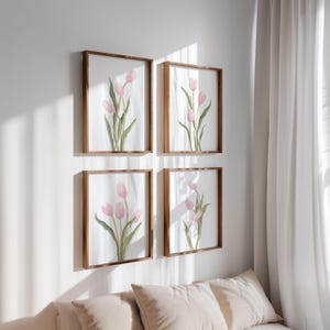 Puede incluir: Cuatro impresiones enmarcadas de pinturas de acuarela de tulipes rosas con tallos y hojas verdes. Las impresiones est&aacute;n dispuestas en una cuadr&iacute;cula en una pared blanca.