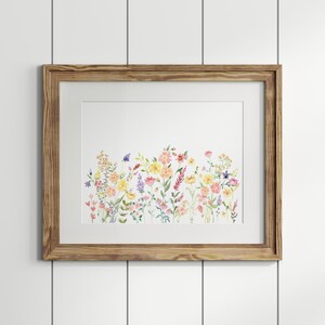 May include: A framed watercolor painting of a field of wildflowers in shades of pink, yellow, and purple. The flowers are arranged in a horizontal row across the canvas.