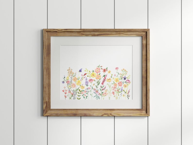 May include: A framed watercolor painting of a field of wildflowers in shades of pink, yellow, and purple. The flowers are arranged in a horizontal row across the canvas.