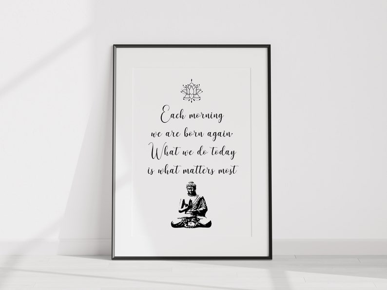 May include: Black and white print with a quote about mindfulness and a lotus flower design. The quote reads "Each morning we are born again. What we do today is what matters most".