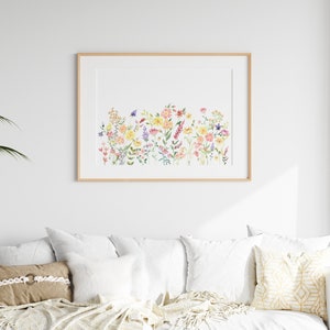 May include: A framed watercolor painting of a field of colorful wildflowers. The flowers are in shades of pink, yellow, orange, and purple. The painting is set against a white background.
