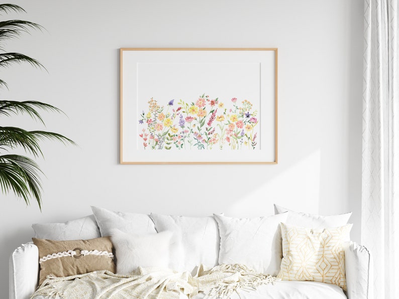 May include: A framed watercolor painting of a field of colorful wildflowers. The flowers are in shades of pink, yellow, orange, and purple. The painting is set against a white background.