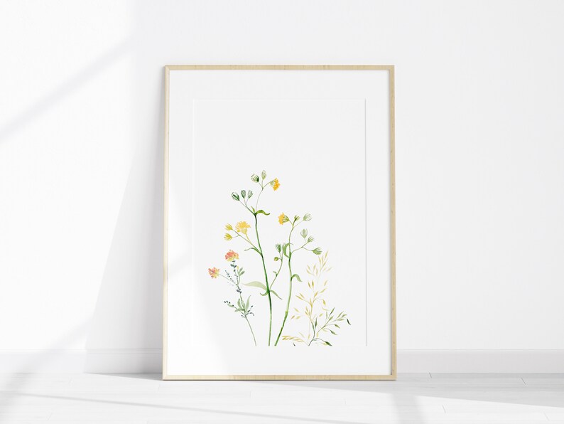May include: A framed watercolor print of delicate yellow and orange wildflowers with green stems on a white background.