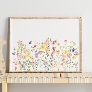 May include: A framed watercolor print of a colorful wildflower bouquet with pink, yellow, and purple flowers. The flowers are arranged in a row across the bottom of the print.