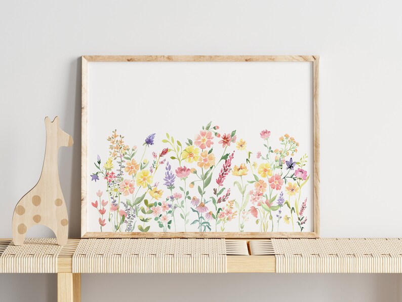 May include: A framed watercolor print of a colorful wildflower bouquet with pink, yellow, and purple flowers. The flowers are arranged in a row across the bottom of the print.